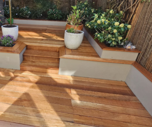 Bespoke timber decking with built-in flower beds and step access, designed and installed by Pierce Project Ltd