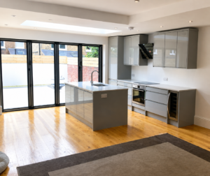 Modern rear extension in Balham with open-plan kitchen, central island, skylight and large aluminium bifold doors