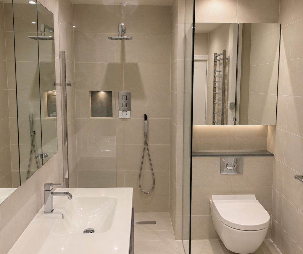 Compact bathroom with bath, glass shower screen, basin and wall-hung toilet